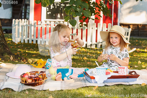 Image of Two little girls sitting on green grass