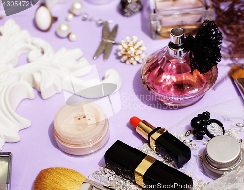 Image of Jewelry table with lot of girl stuff on it, little mess in cosmetic brushes, women interior concept, perfume elegance things, little princess makeup