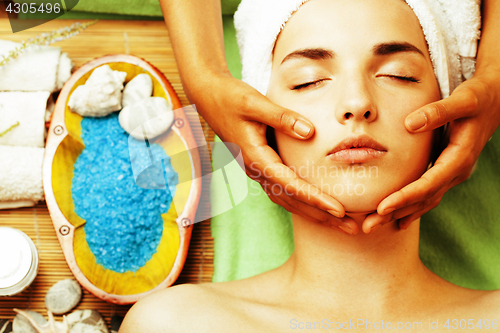 Image of stock photo attractive lady getting spa treatment in salon, close up asian hands on face