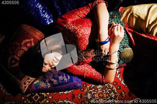 Image of young pretty asian girl in bright colored interior