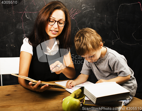 Image of little cute boy with teacher in classroom