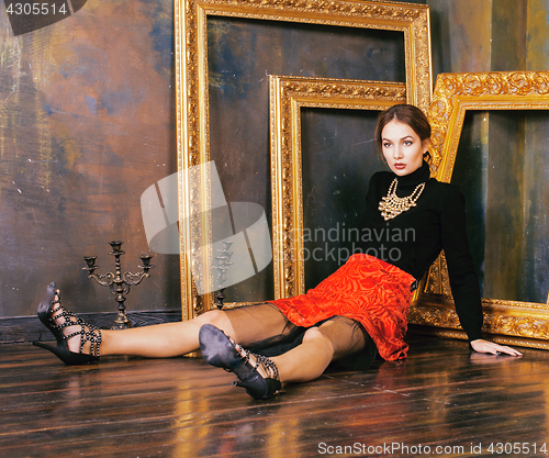Image of beauty rich brunette woman in luxury interior near empty frames, vintage elegance