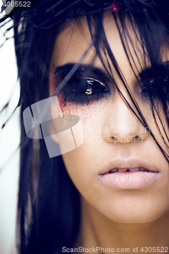 Image of pretty brunette woman with make up like demon at halloween