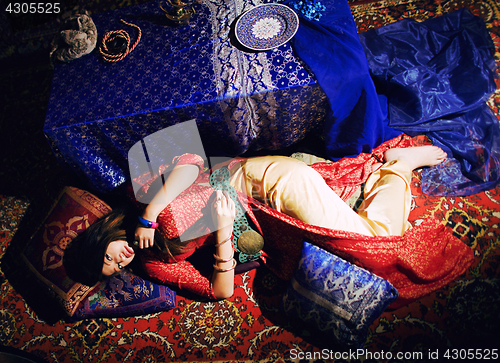 Image of young pretty asian girl in bright colored interior