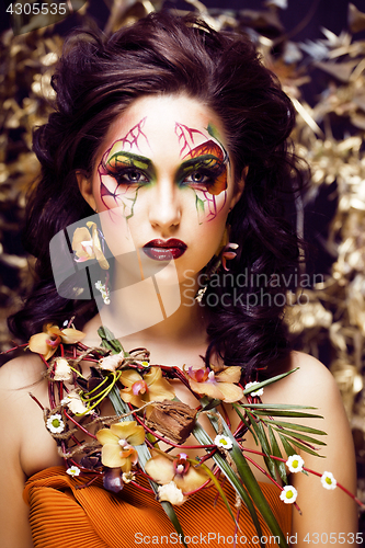 Image of beauty woman with face art and jewelry from flowers orchids