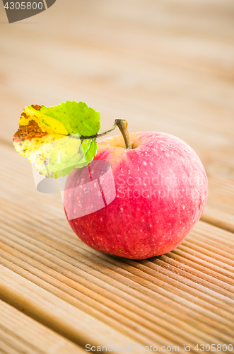Image of Ripe red apple with a leaf, close-up