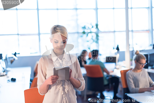 Image of woman working on digital tablet in night office