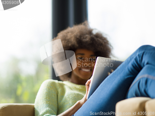Image of young african american woman at home using digital tablet