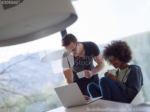 Image of multiethnic couple relaxing at modern home indoors