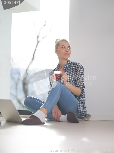 Image of young woman drinking coffee enjoying relaxing lifestyle