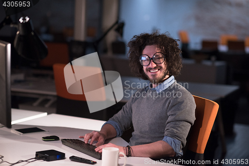 Image of man working on computer in dark startup office