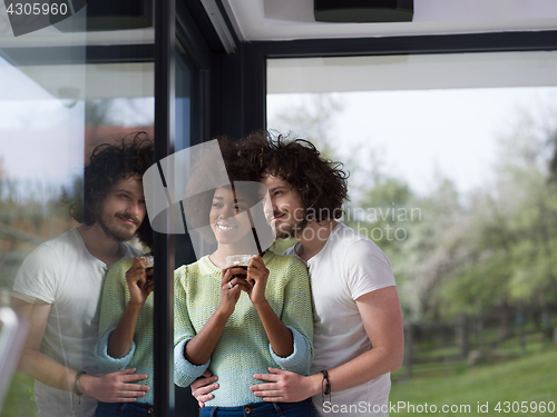 Image of happy multiethnic couple relaxing at modern home indoors