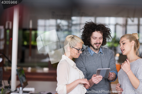 Image of group of Business People Working With Tablet in startup office