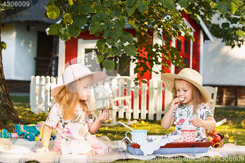 Image of Two little girls sitting on green grass
