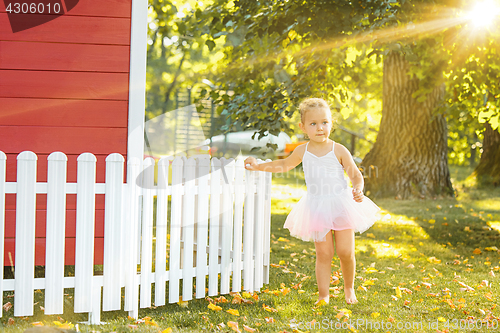 Image of The little girl at playground against park or green forest