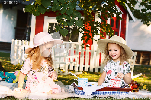 Image of Two little girls sitting on green grass