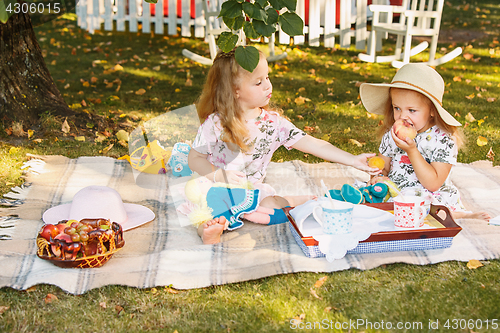 Image of Two little girls sitting on green grass