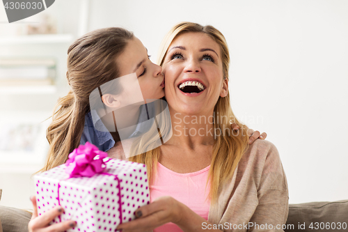 Image of girl giving birthday present to mother at home