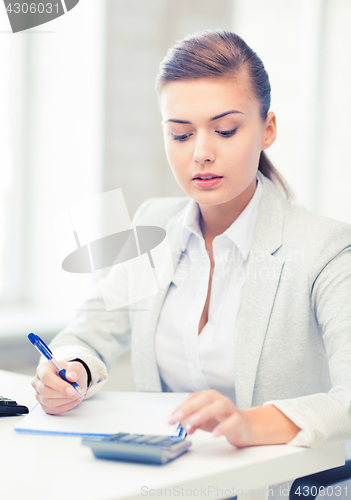 Image of businesswoman with notebook and calculator