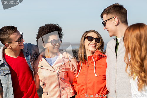 Image of happy teenage friends in shades talking on street