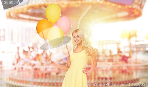 Image of happy woman with air balloons over carousel