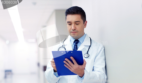 Image of doctor with clipboard at hospital corridor