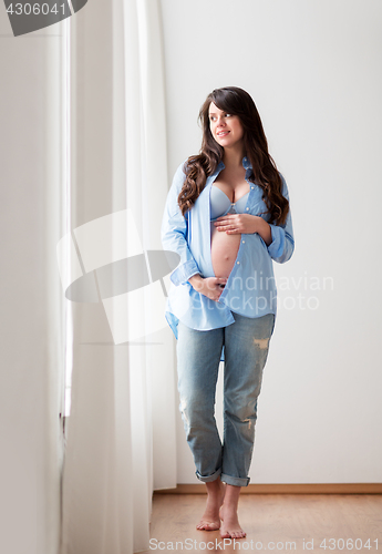 Image of happy pregnant woman with big tummy at home