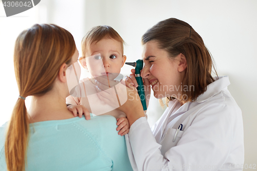 Image of doctor with otoscope checking baby ear at clinic