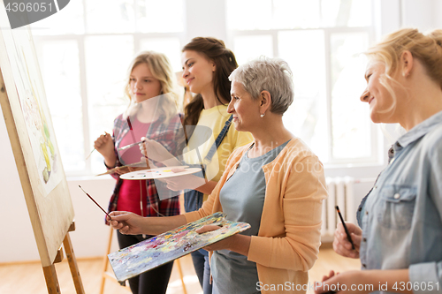 Image of women with easel and palettes at art school