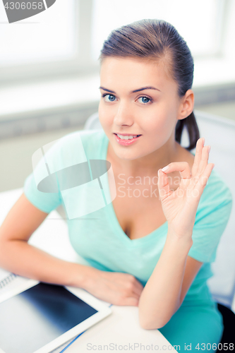 Image of girl with tablet pc showing ok gesture