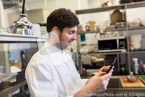 Image of chef cook with tablet pc at restaurant kitchen