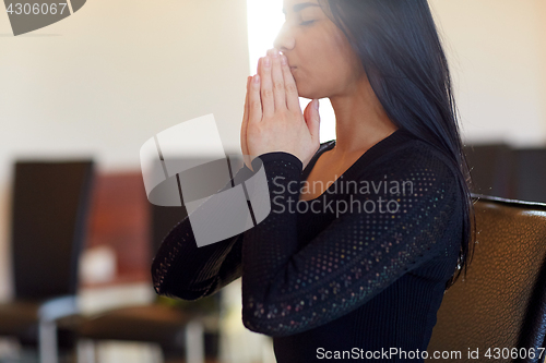 Image of close up of sad woman praying god in church