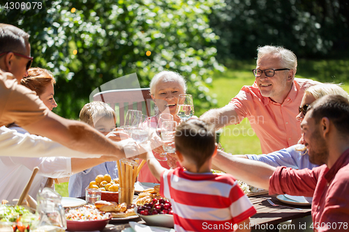 Image of happy family having dinner or summer garden party