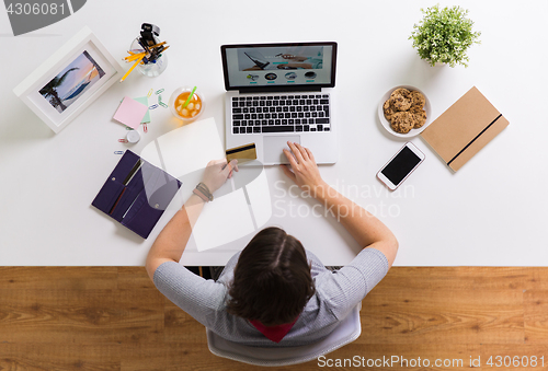 Image of woman with laptop and credit card at table