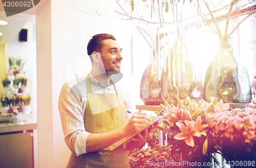 Image of florist man with clipboard at flower shop