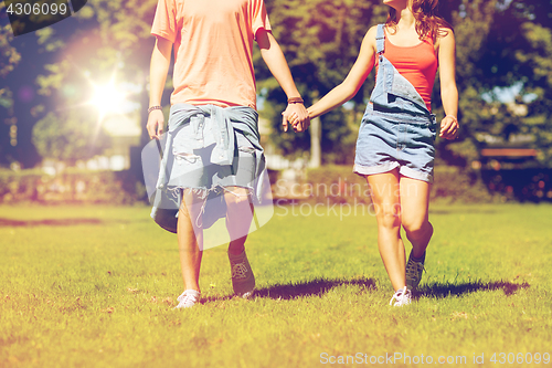 Image of happy teenage couple walking at summer park