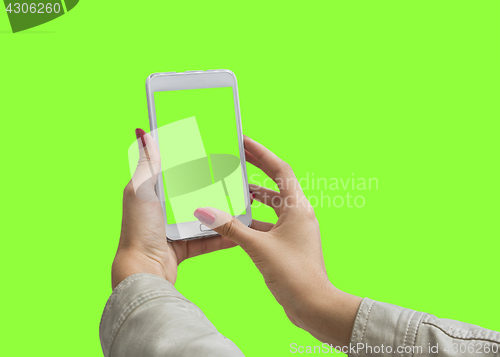 Image of Young girl hand holding mobile smart phone on green screen