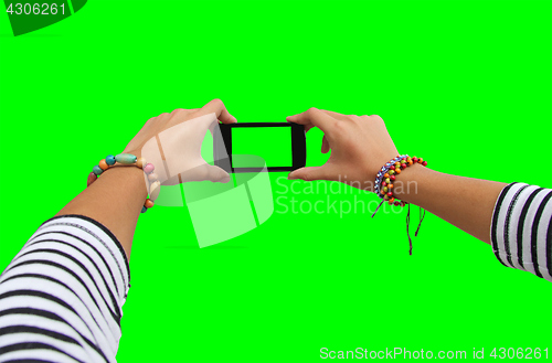 Image of Young girl hand holding mobile smart phone on green screen