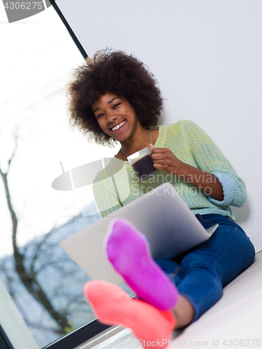 Image of black woman in the living room on the floor