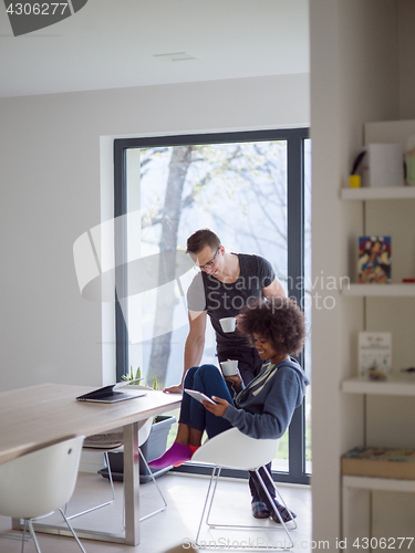 Image of multiethnic couple relaxing at modern home indoors