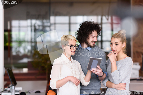 Image of group of Business People Working With Tablet in startup office