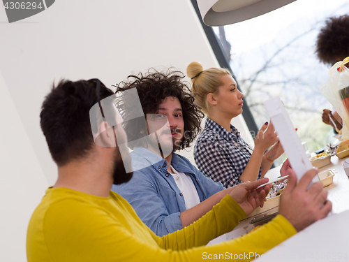 Image of multiethnic group of happy friends lunch time