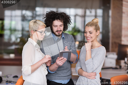 Image of group of Business People Working With Tablet in startup office