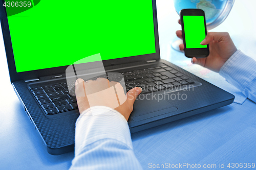 Image of Women hands working on laptop and smart phone in office on green