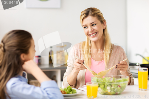 Image of happy family eating salad at home kitchen