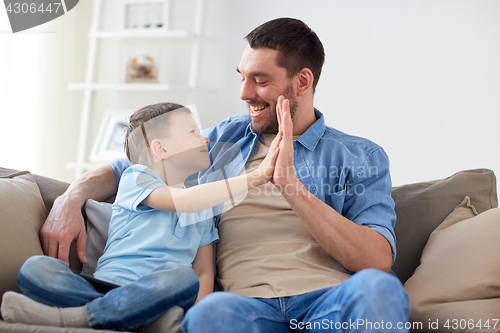 Image of father and son doing high five at home