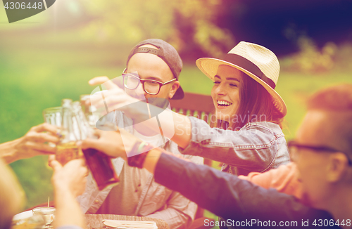 Image of happy friends clinking glasses at summer garden