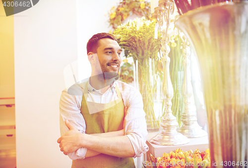 Image of happy smiling florist man standing at flower shop