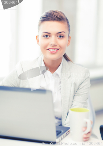 Image of businesswoman with laptop in office