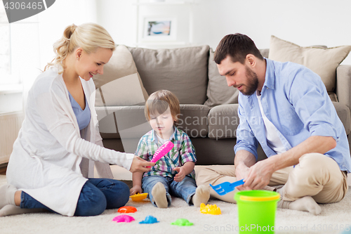 Image of happy family playing with beach toys at home